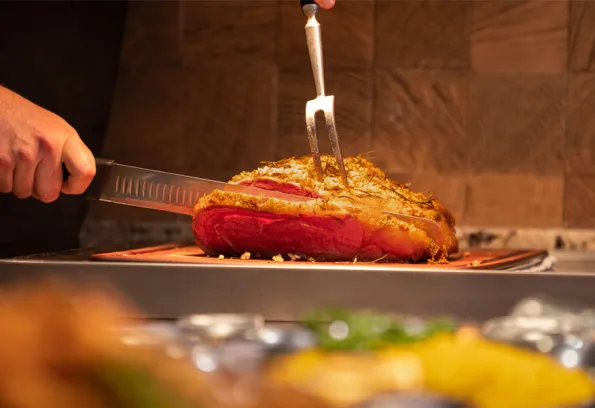 Man slicing a cooked prime rib at Big Lake Buffet at Little River Casino Resort