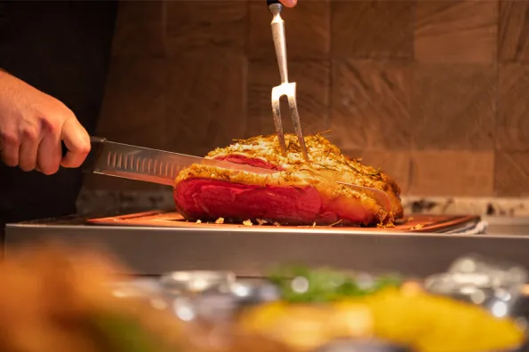 Man slicing a cooked prime rib at Big Lake Buffet at Little River Casino Resort