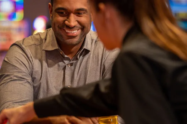 man smiling at dealer during table game 