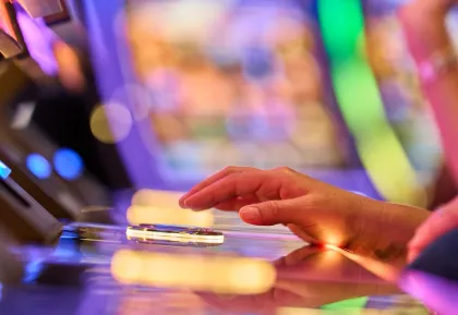 Hand pushing play button on slot machine