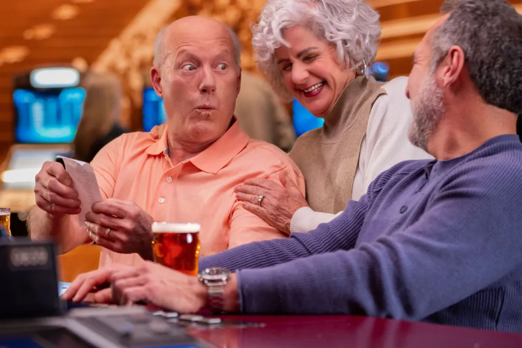 older couple looking at their betting ticket with surprised faces